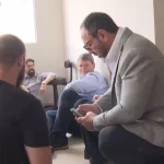 Candidato e equipe sentados no chão após tiroteio - Foto: Reprodução Rede Globo