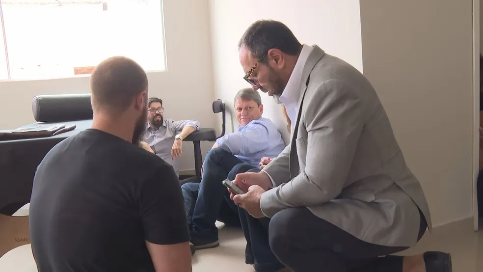 Candidato e equipe sentados no chão após tiroteio - Foto: Reprodução Rede Globo