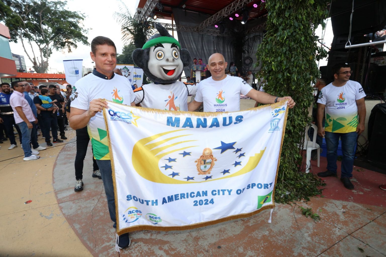 O vice-prefeito, Marcos Rotta, e o diretor-presidente da Fundação Manaus Esporte, Aurilex Moreira, seguram a bandeira da Cidade Sul-Americana do Desporto em 2024