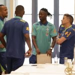 Éder Militão e Vinicius Junior com os integrantes da comissão técnica