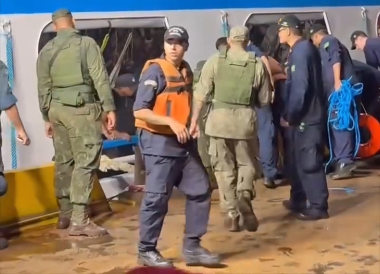 Mulher sendo resgatada após cair entre balsa e barco em Manaus
