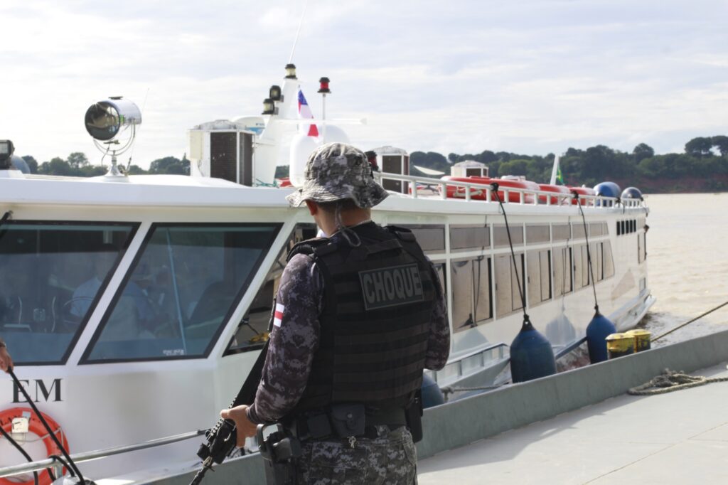 Policial vistoria barco na Amazônia
