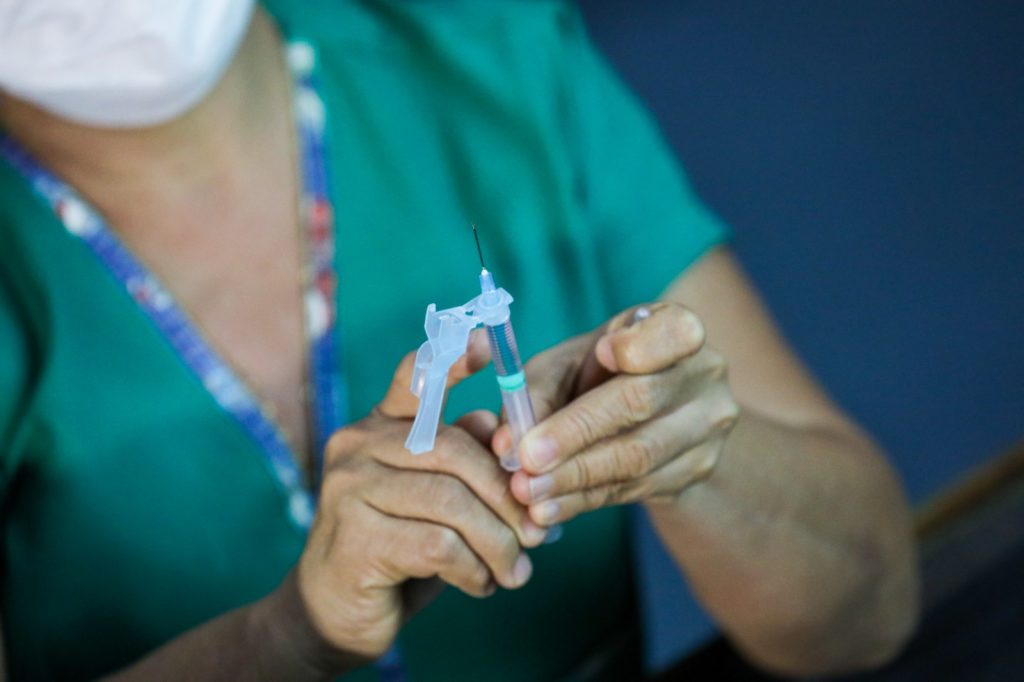 Criança sendo vacinada com dose pediátrica da Pfizer em unidade de saúde de Manaus