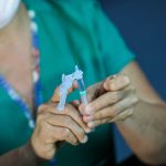 Criança sendo vacinada com dose pediátrica da Pfizer em unidade de saúde de Manaus