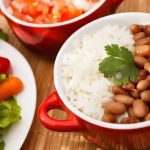 Prato de arroz com feijão ao lado de salada verde – exemplo de refeição com leguminosas para saúde do coração
