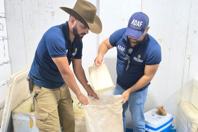 Fiscais da Adaf apreendendo queijo e mariscos clandestinos no porto de Parintins