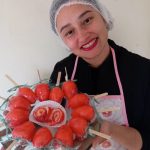 Confeiteira Cláudia Nicoleti segura morango do amor em Senador Amaral