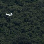Avião comercial sobrevoando região amazônica com foco em transporte aéreo