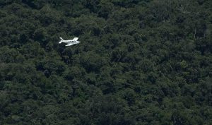 Avião comercial sobrevoando região amazônica com foco em transporte aéreo