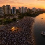 Fiéis reunidos na Praia da Ponta Negra durante evento cristão ao amanhecer em Manaus