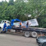 Equipe do Implurb executando a retirada de outdoors em área de obra do complexo viário “Passarão”