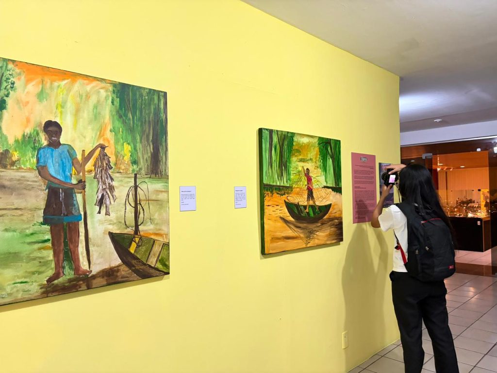 Visitantes observam obras da exposição Yúpury: Infância Tukano em Manaus.